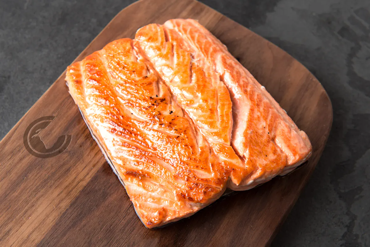 Seared Copper River sockeye salmon fillets on a wooden board