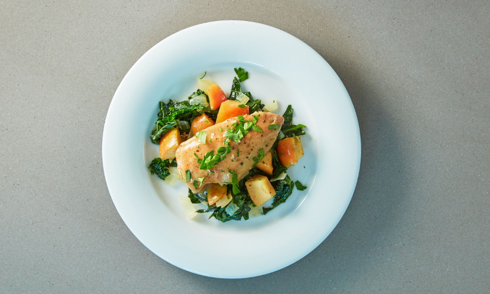 Honey Dijon chicken breast plated with apples and greens, viewed from above