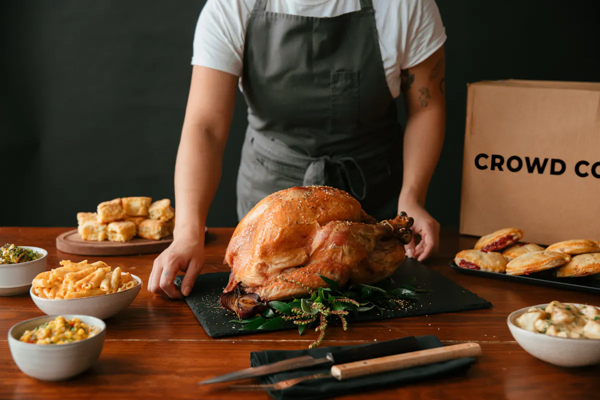 A roast turkey on a Thanksgiving table with sides and a Crowd Cow box