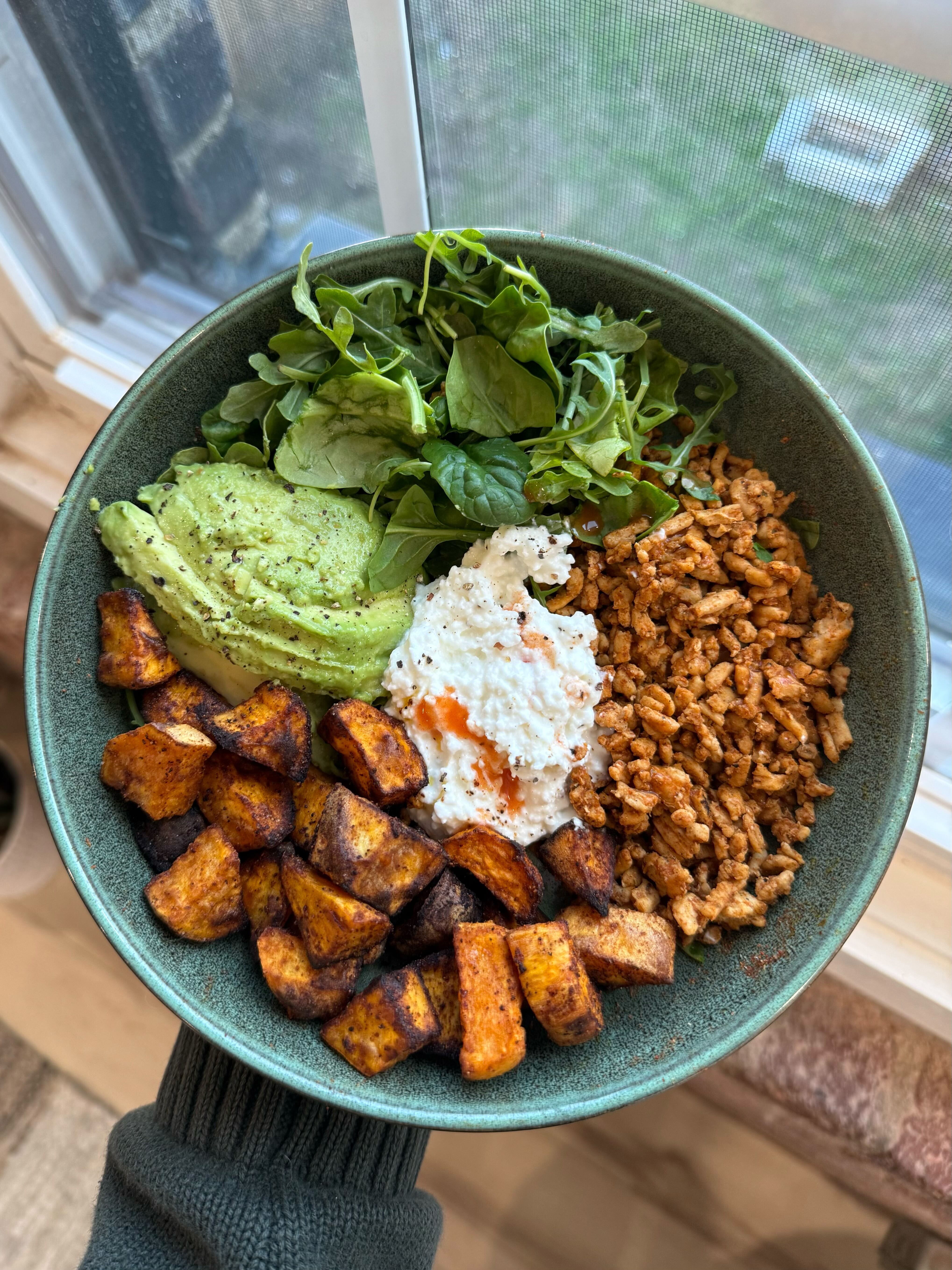 A bowl of hot honey ground meat with roasted sweet potatoes, avocado, greens and cottage cheese